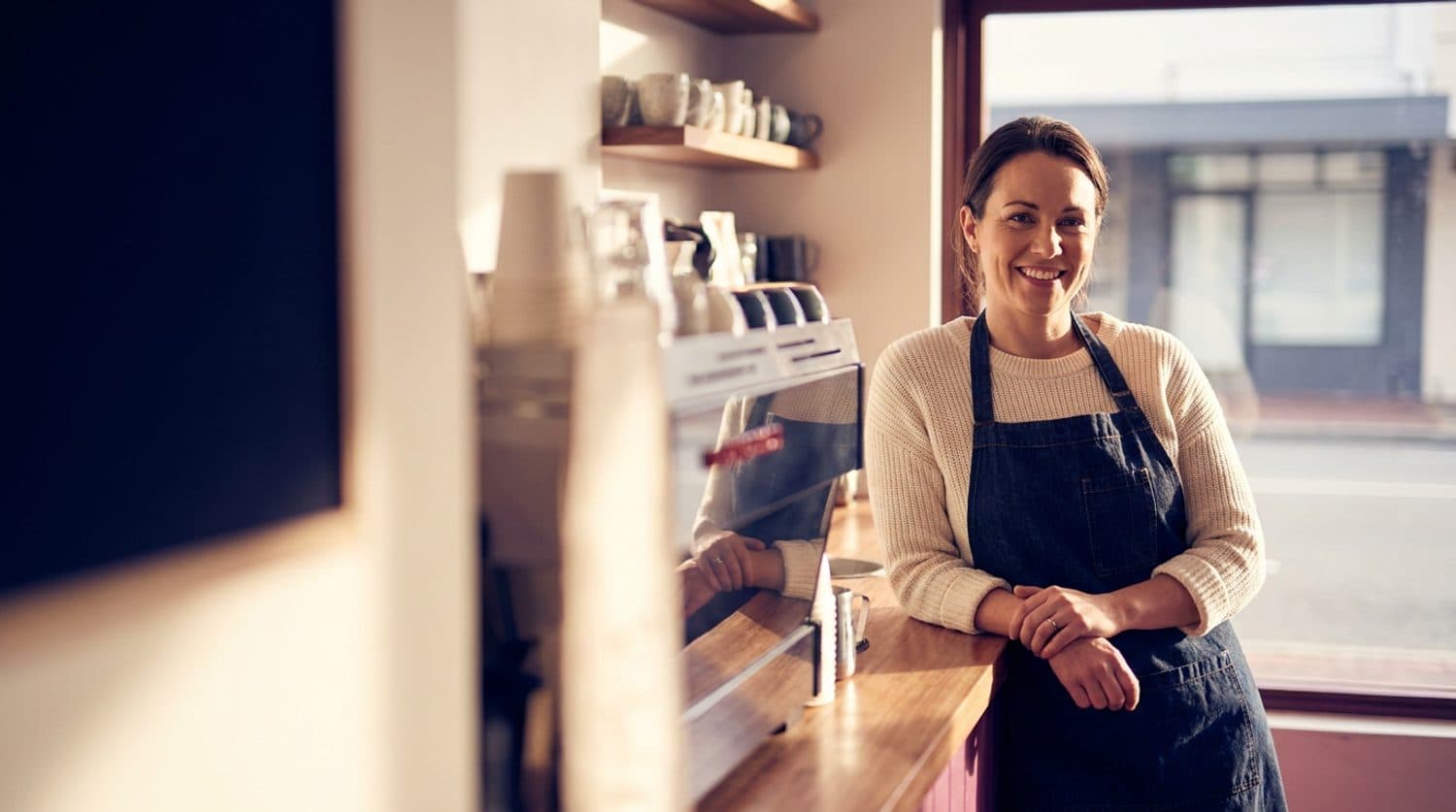 A Perth café owner behind the counter of her light-filled café